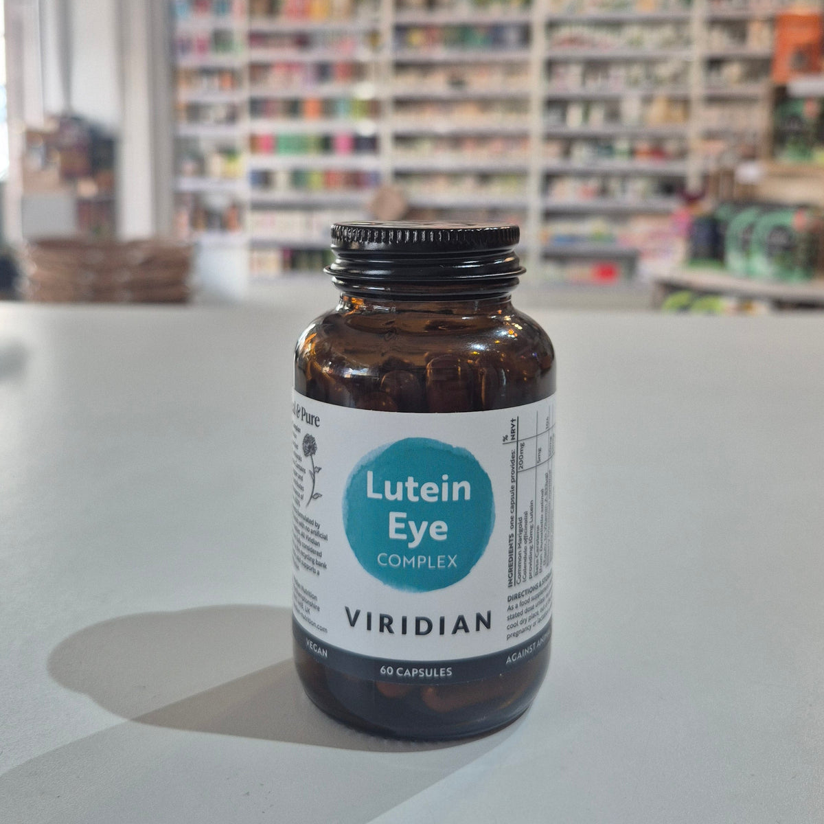 Bottle of Viridian Lutein Eye Complex on a counter with a blurred store background