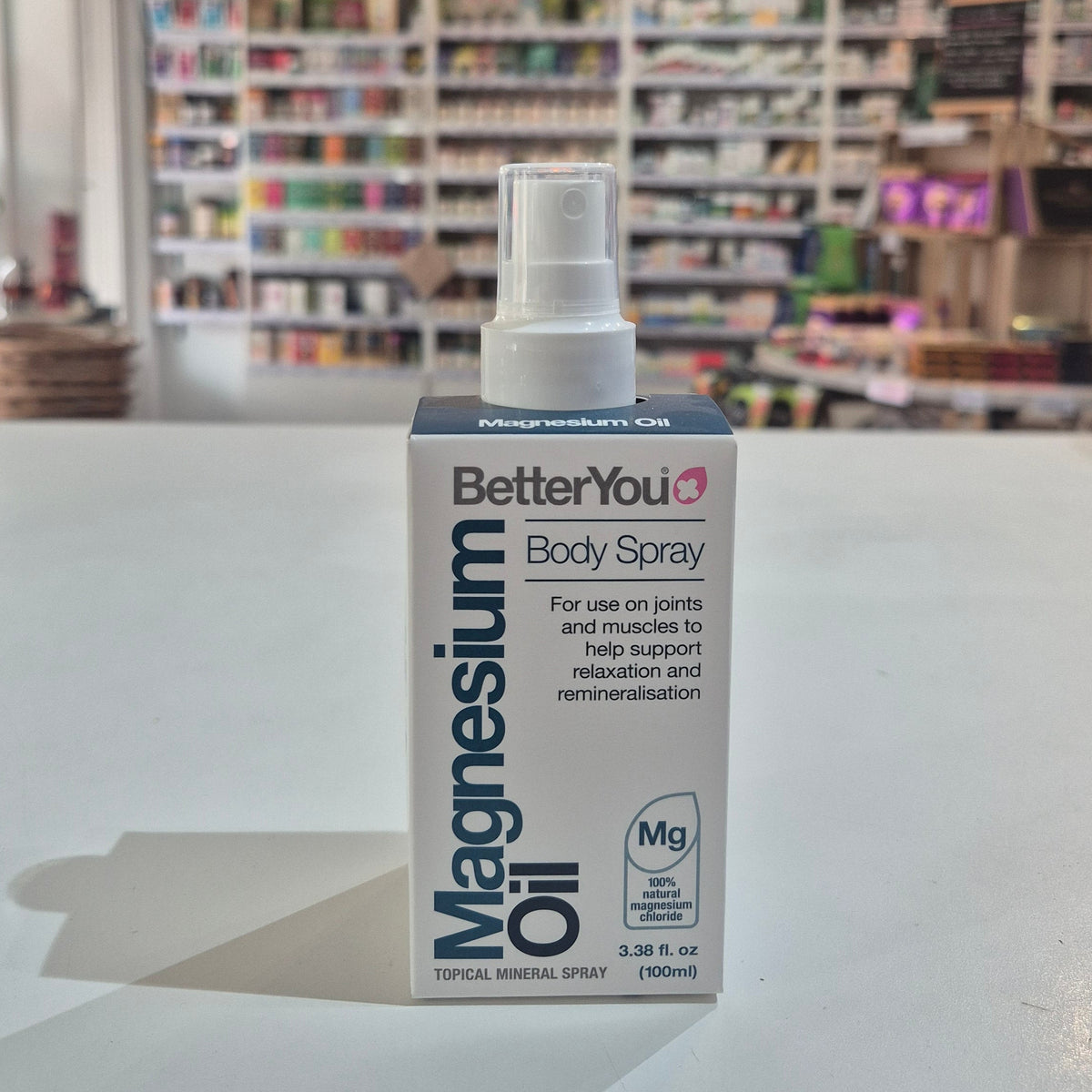 BetterYou Magnesium Oil Body Spray bottle on a counter with a store shelf in the background