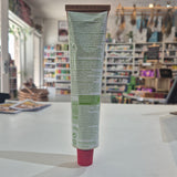 A squeeze tube of Tartex pate, lying horizontally on a white surface with a blurred store background.