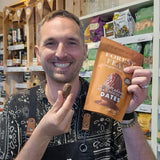 Man holding a package of Forest Feast chocolate dates in a store setting