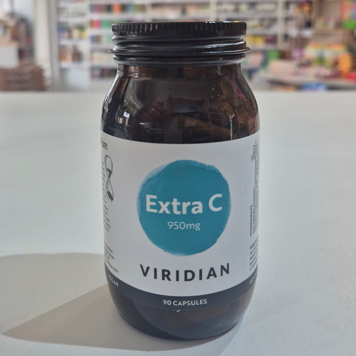Bottle of Viridian Extra C supplement on a white surface with a blurred background
