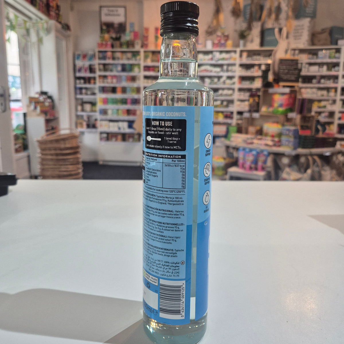 Bottle of Hunter Gatherer MCT oil on a white surface with a blurred store background