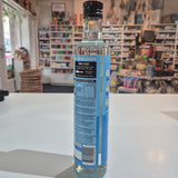 Bottle of Hunter Gatherer MCT oil on a white surface with a blurred store background