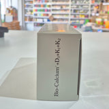 Box labeled 'Bio-Calcium + D3+K2' in a store setting with blurred shelves in the background.