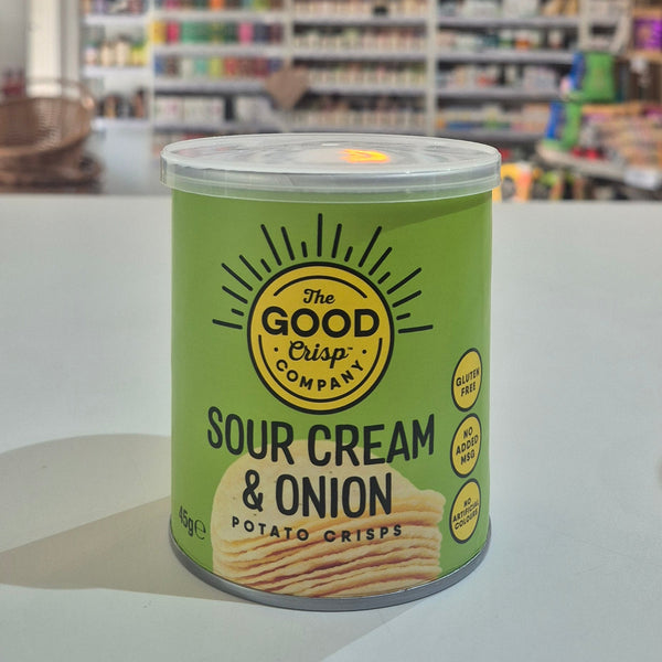 Can of 'Sour Cream & Onion' potato crisps from The Good Crisp Company on a white surface with a blurred store background.