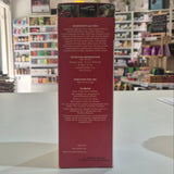 A tall red product box for Herbetom standing upright on a white surface, photographed in a retail store with shelves of other products blurred in the background. The front of the box is not visible, so only the back panel is shown, with small white text including ingredients, nutrition info, and directions.