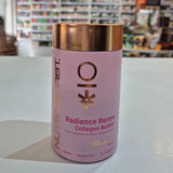 Pink supplement container with gold lid on a white surface, blurred store shelves in the background