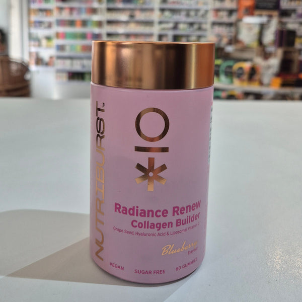 Pink supplement container with gold lid on a white surface, blurred store shelves in the background