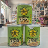 Three cans of Good & Gather Sour Cream & Onion potato chips on a reflective surface with a store interior in the background.