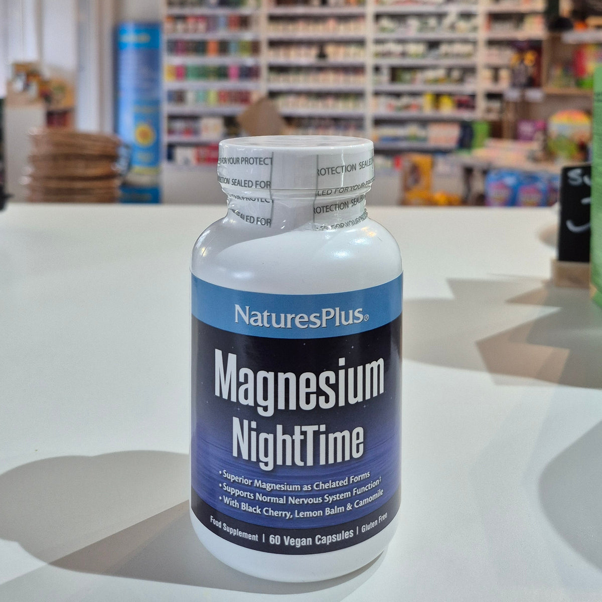 NaturesPlus Magnesium NightTime supplement bottle on a store shelf background