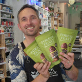 Man holding Forest Feast snack packages in a store setting