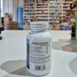 Vitamin supplement bottle with nutrition information label on a store shelf background