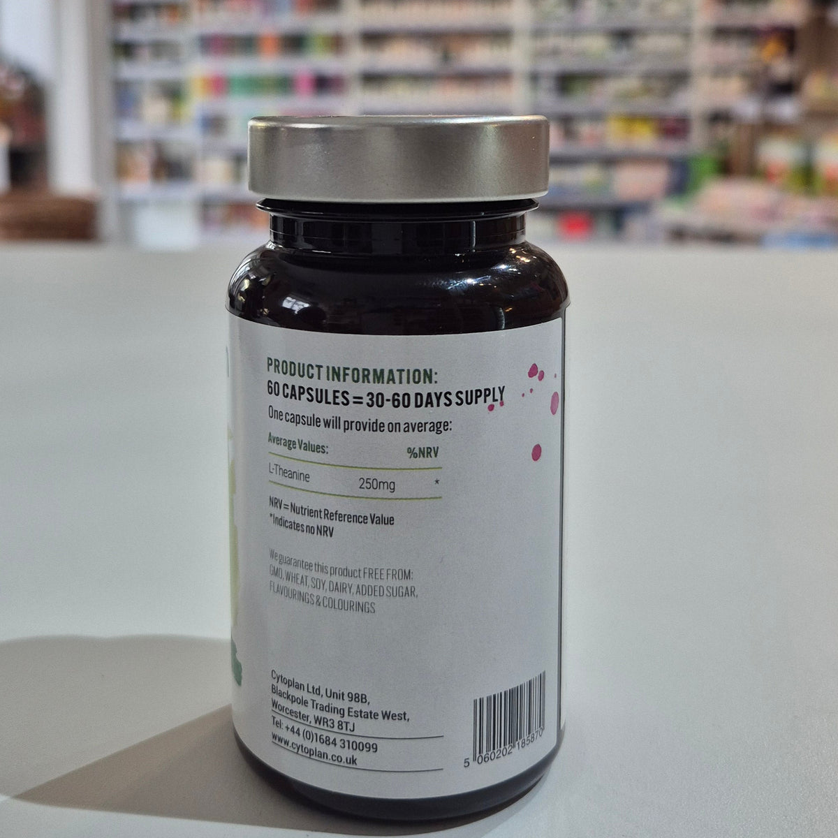 Bottle of supplements on a white surface with a blurred store background