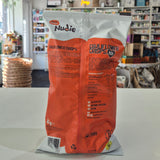 Nudie Cauliflower Crisps packaging on a white surface with a blurred store background