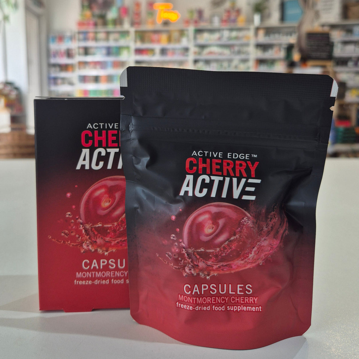 Two packages of Active Edge Cherry Active capsules on a shelf with a blurred store background.