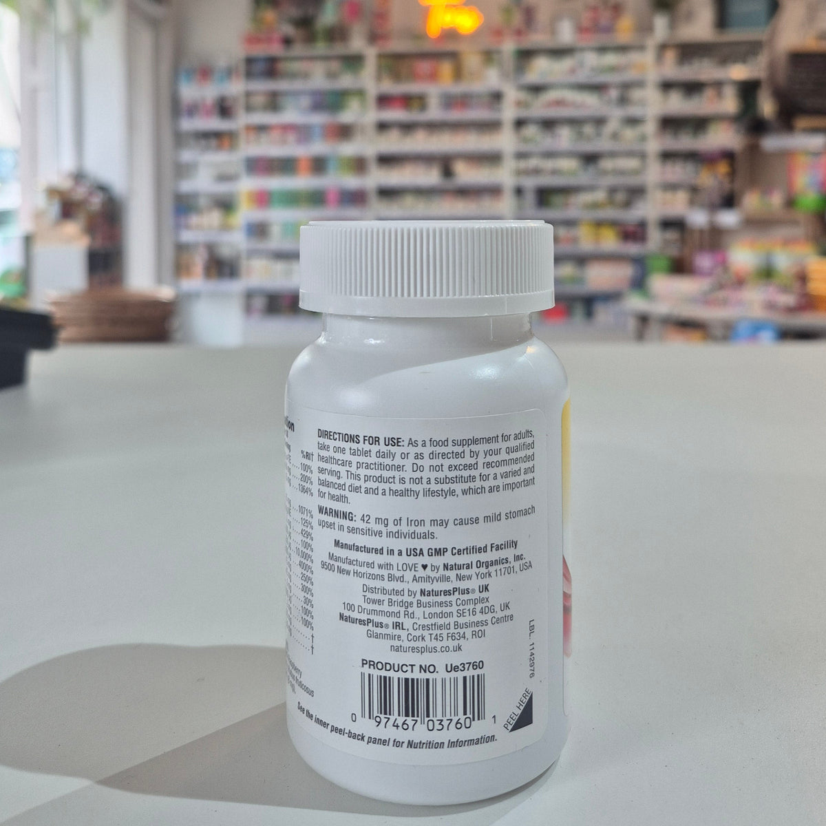 Bottle of Natures Plus Hema-Plex Tablets 42mg Elemental Iron, 30 capsules on a white surface with a blurred indoor background.