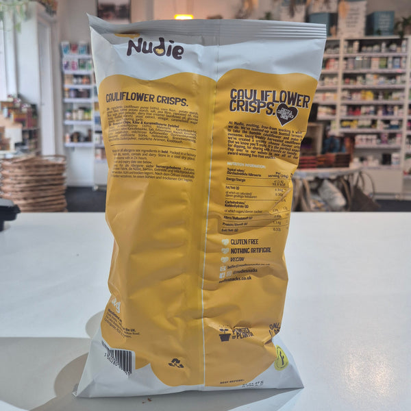 Yellow and white package of Nudie Skins on a white surface with a blurred indoor background