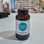 Magnesium Citrate in a bottle with a label on a white surface, blurred store interior in the background