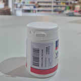 Lamberts Vitamin B12 supplement container on a table with a blurred background. White container with a label on a light gray surface, blurred background