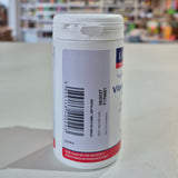 White supplement container with label on a white surface, blurred background
