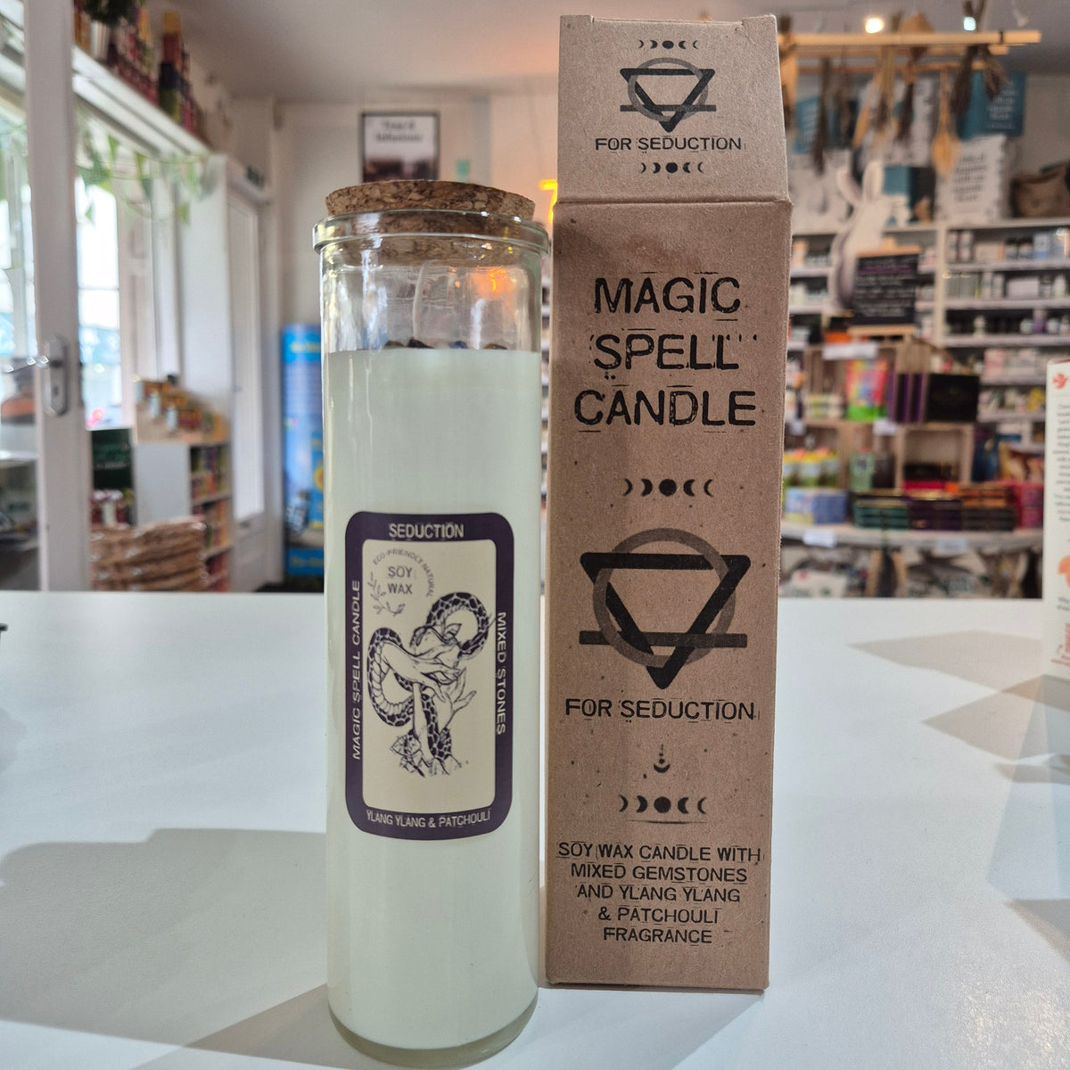 Candle with packaging labeled 'Magic Spell Candle' in a store setting