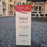 A 250 ml box of Herbetom Transit food supplement, standing upright on a dark gray carpeted floor with a blurred indoor background.