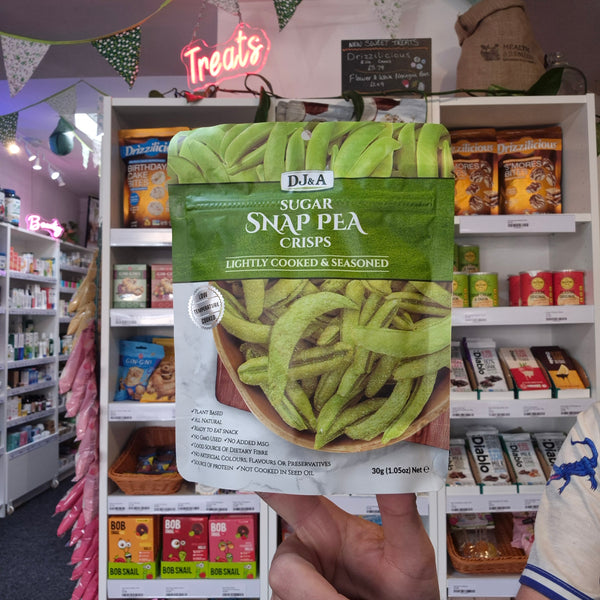 A hand holds a package of DJ&A Sugar Snap Peas
