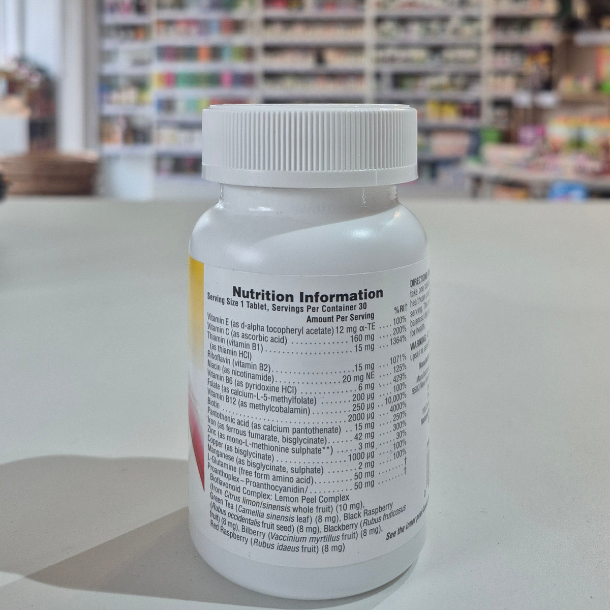 Bottle of Natures Plus Hema-Plex Tablets 42mg Elemental Iron, 30 capsules on a white surface with a blurred indoor background.