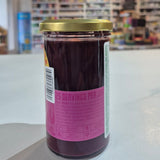 Jar with a pink label on a shelf in a store setting