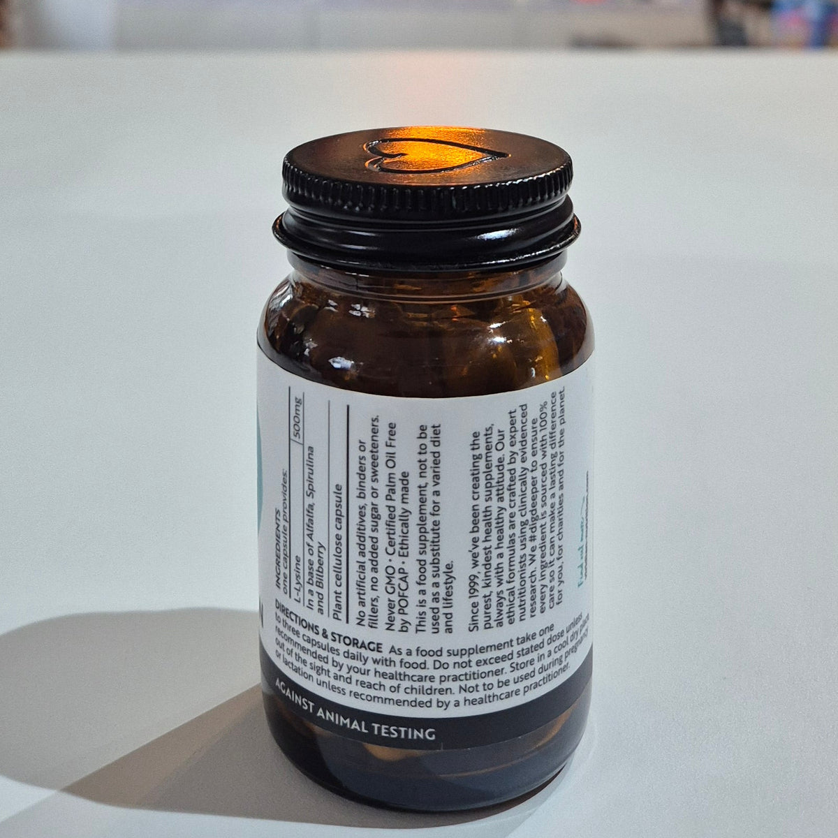 Bottle of medicine on a white surface with a blurred background of shelves with products.