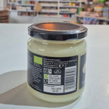 Jar with a label on a white surface, blurred background of shelves with products Organic Tallow.