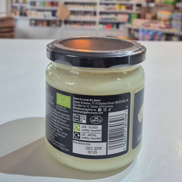 Jar with a label on a white surface, blurred background of shelves with products Organic Tallow.