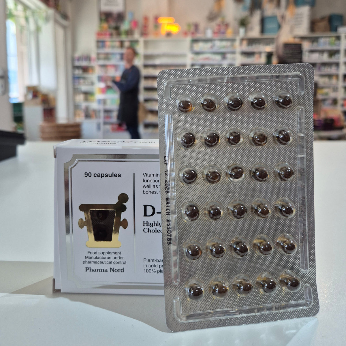 Packaging of capsules with a blurred indoor background