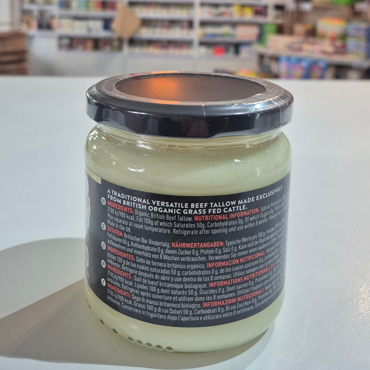 Jar of cream with a blurred store interior in the background