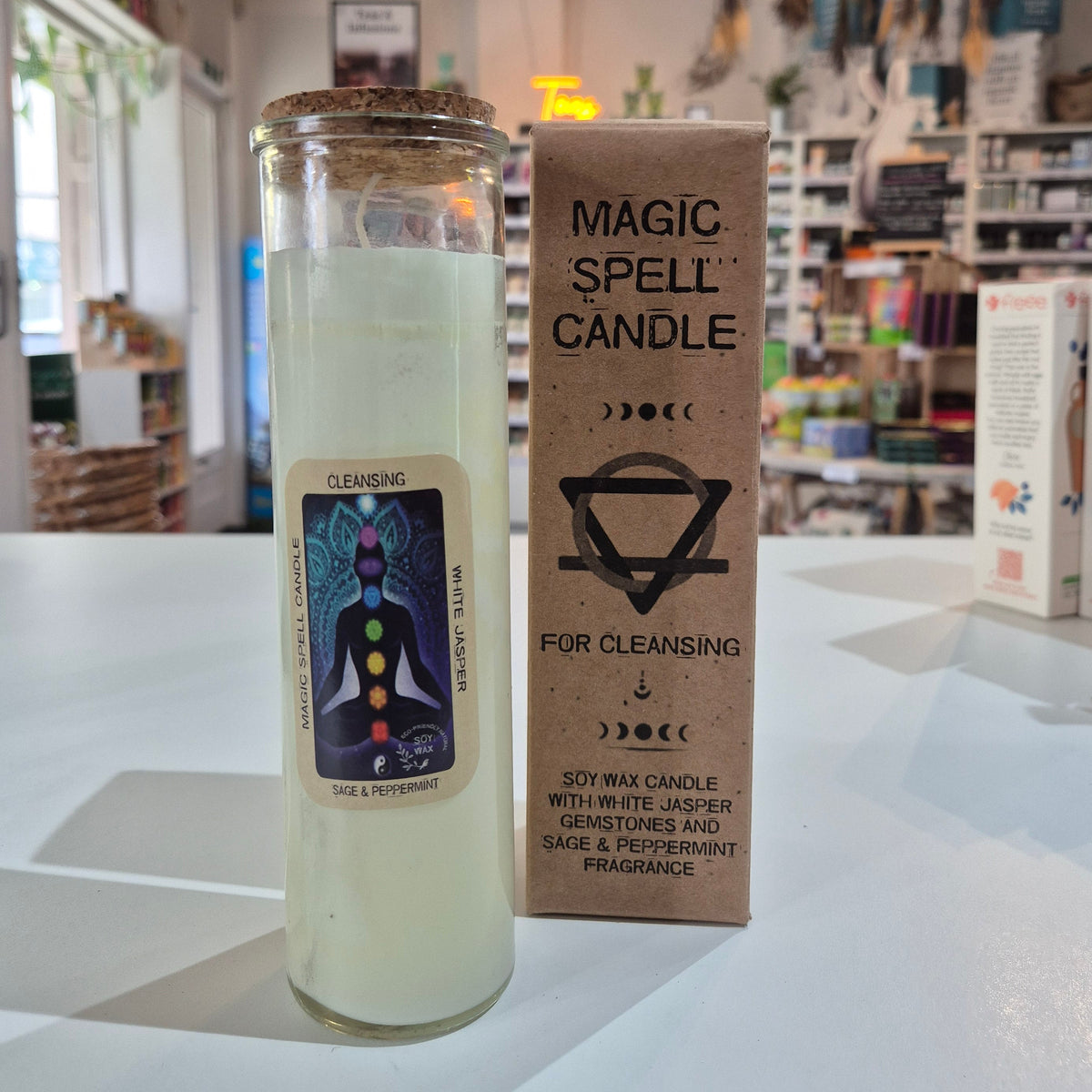 Candle with packaging labeled 'Magic Spell Candle' on a white surface.