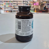Brown supplement bottle with label on a white surface, blurred store shelves in the background