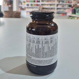 Bottle of Viridian Lutein Eye Complex on a counter with a blurred store background. Brown supplement bottle with label on a white surface, blurred store background