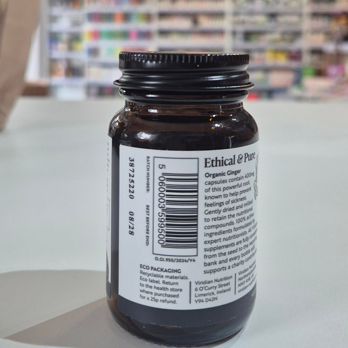 Brown glass bottle with a label on a white surface, blurred background
