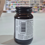 Brown glass bottle with a label on a white surface, blurred background