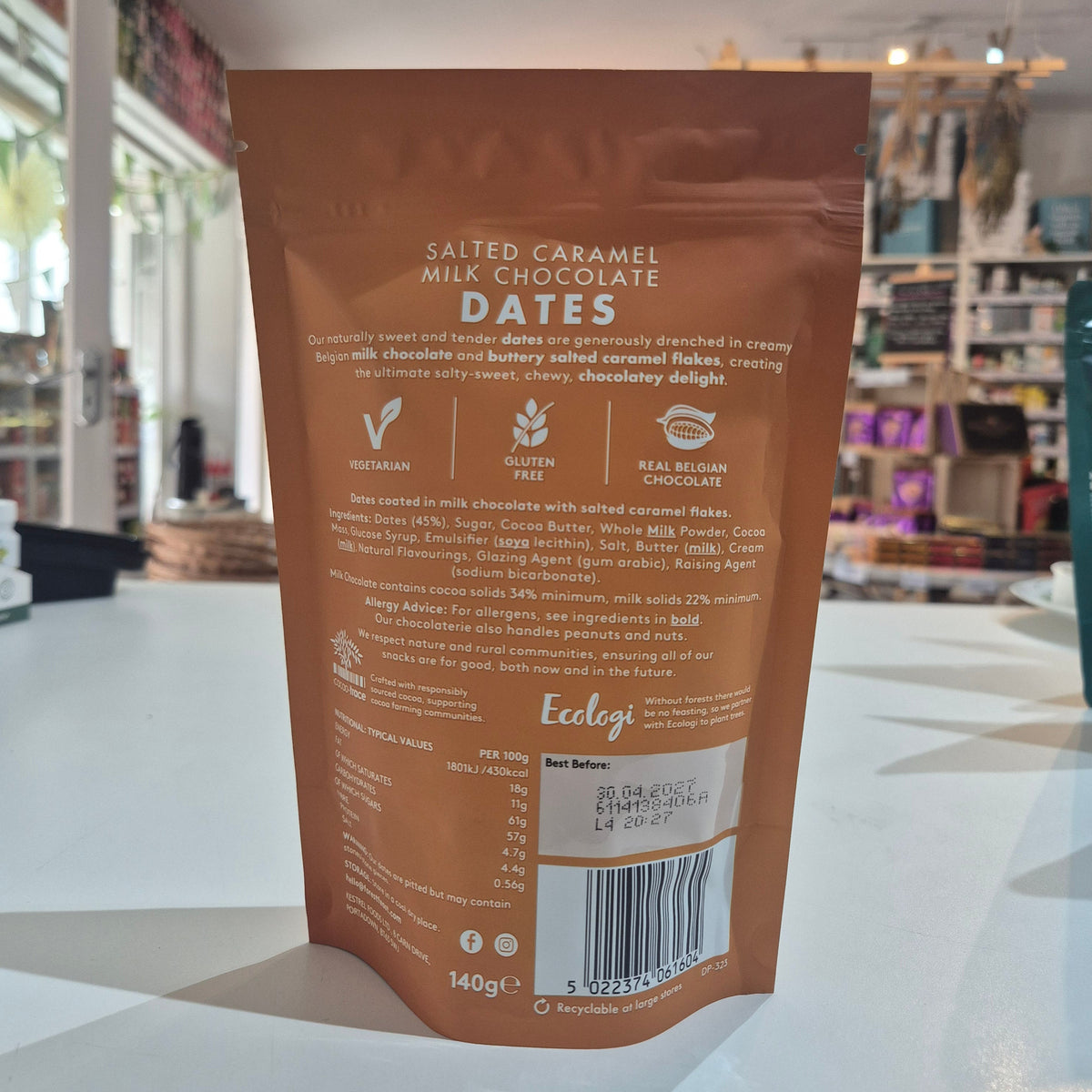 Brown package of salted caramel milk chocolate dates on a white surface with a blurred background