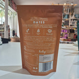 Brown package of salted caramel milk chocolate dates on a white surface with a blurred background