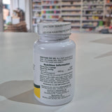 Nature's Plus Shot-O-B12 5000 Mcg lozenge in a white bottle with green and purple label, indicating wild berry flavor and dietary supplement category. Supplement bottle with nutritional information on a table in a store setting