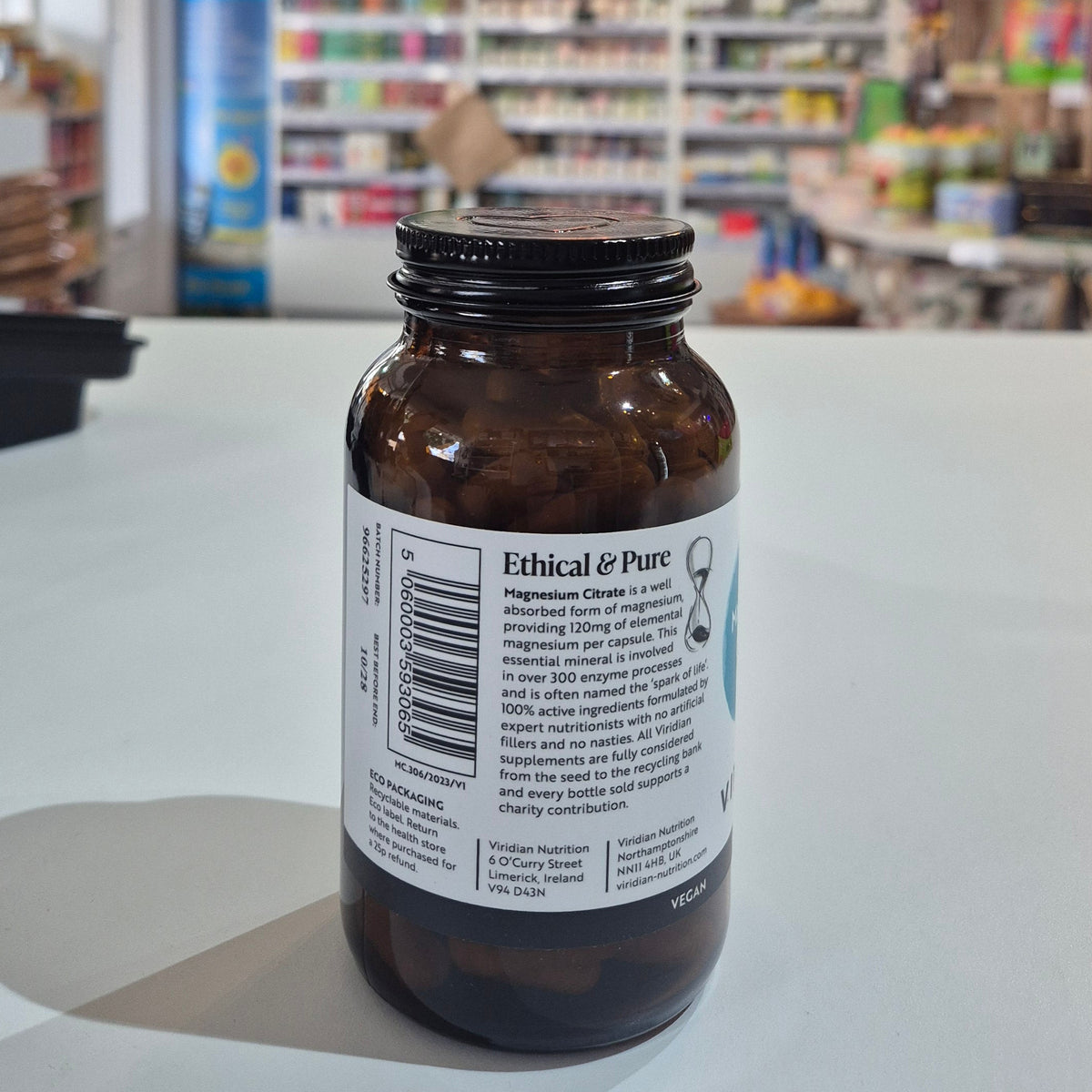 Brown bottle with a label on a white surface in a store setting
