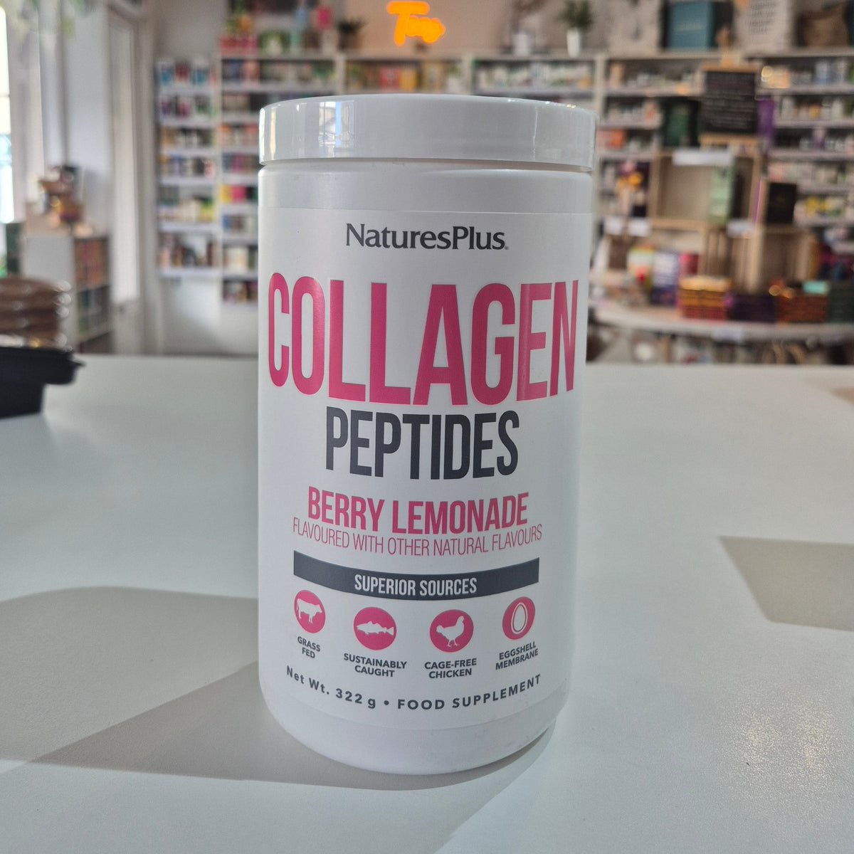 NaturesPlus Collagen Peptides container on a table with a blurred store background
