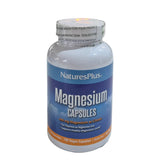 Bottle of NaturesPlus Magnesium Capsules on a white surface with a white background