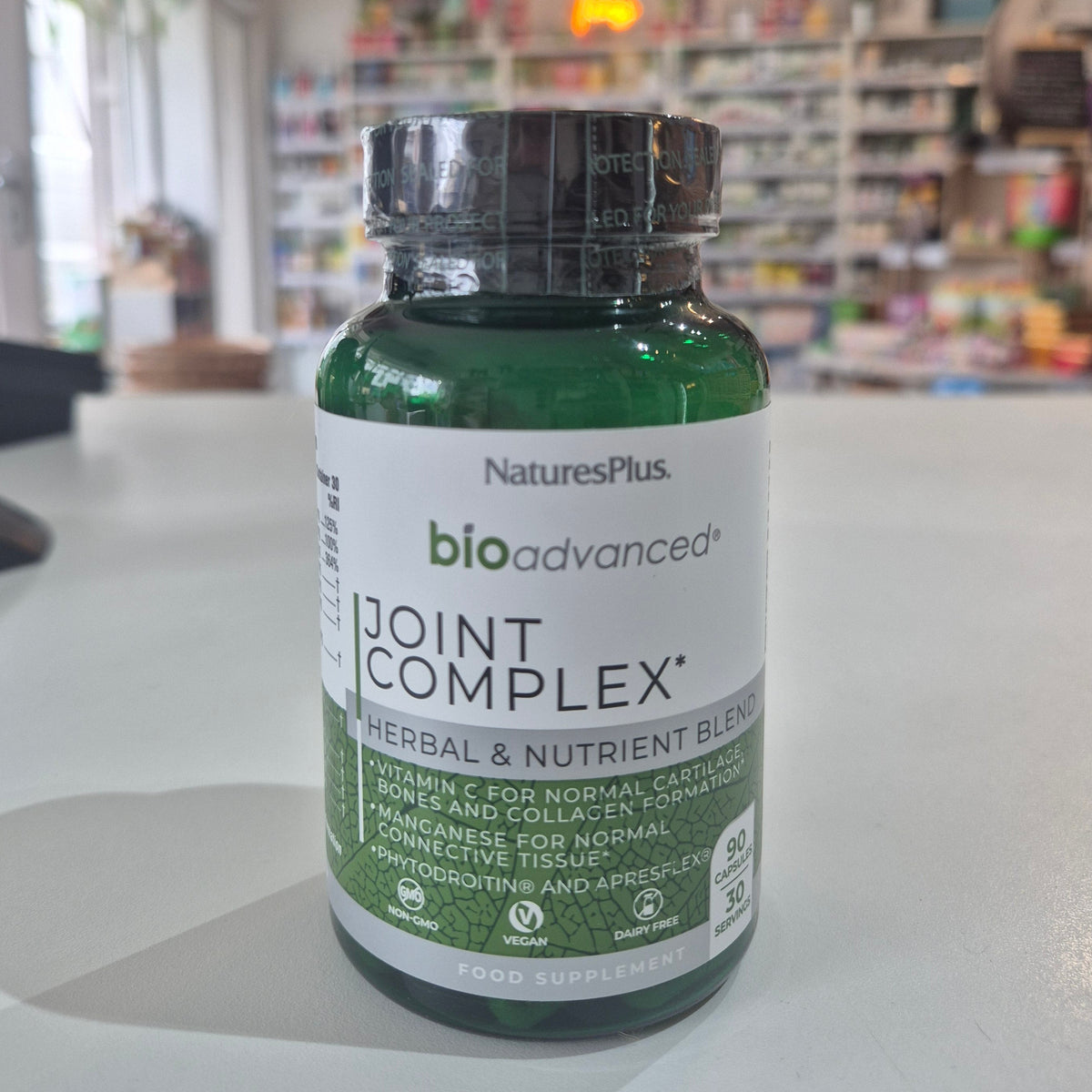 Bottle of NaturesPlus BioAdvanced Joint Complex on a table with a blurred store background