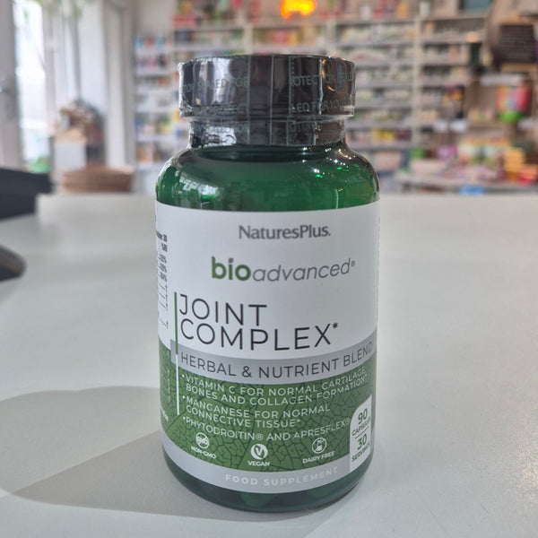 Bottle of NaturesPlus BioAdvanced Joint Complex on a table with a blurred store background