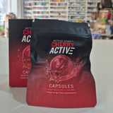 Two 'Active CherryActive' supplement packages on a white surface with a blurred background.