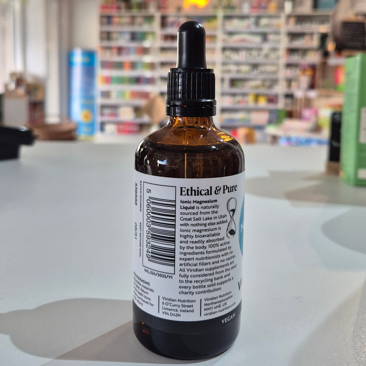 Bottle of Ethical & Pure liquid on a surface with a blurred store background