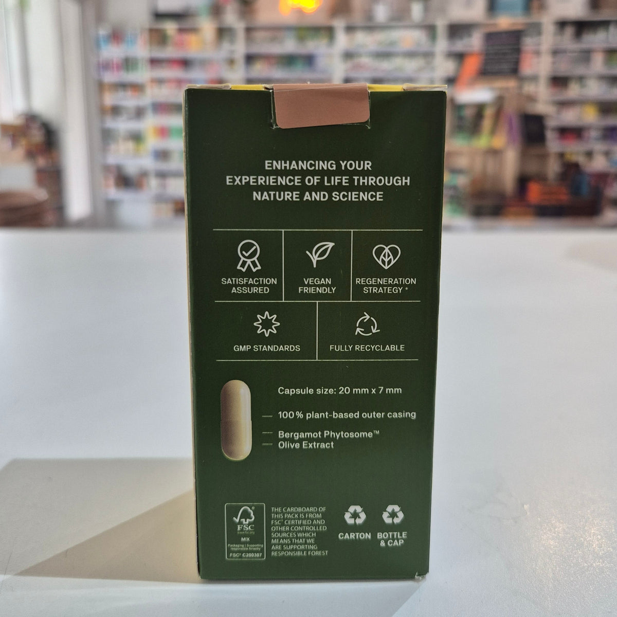 Green packaging box with text and icons on a blurred background